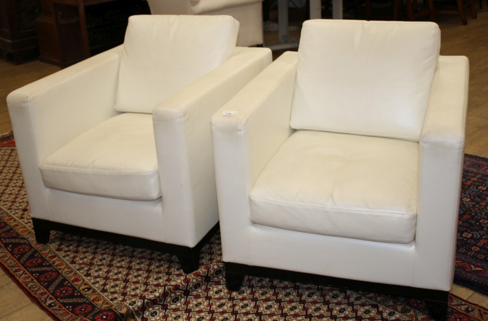 A pair of modern Italian cream leather upholstered armchairs, with ebonised feet, W.80cm D.90cm H.86cm